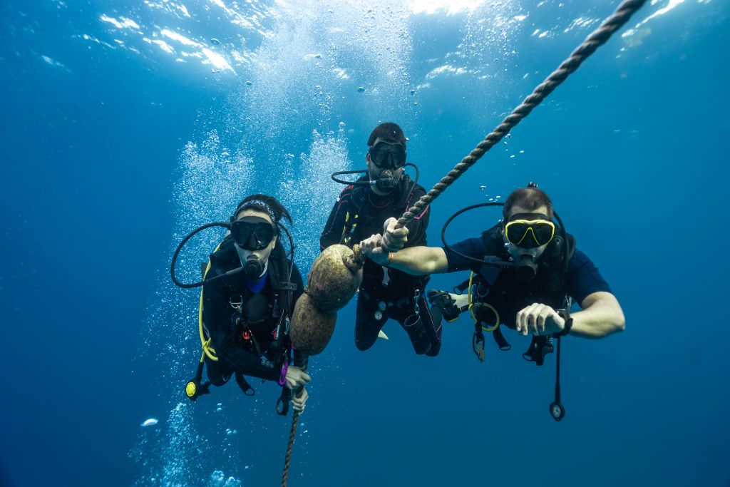 Three divers by the anchor line.