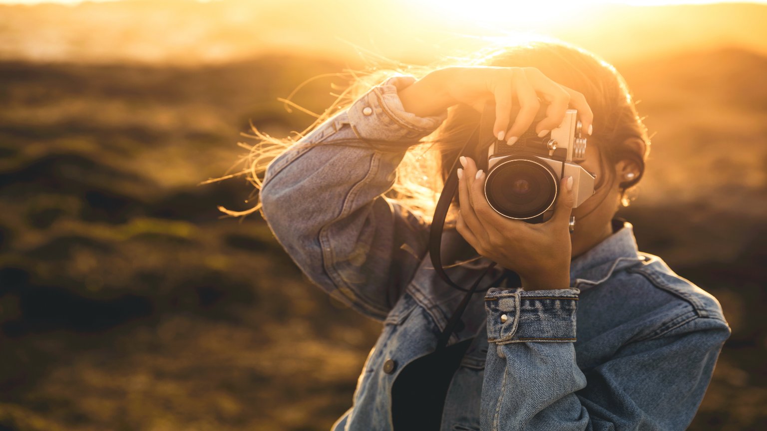 A woman taking pictures during golden hour